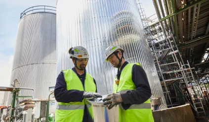 Mitarbeiter beraten sich in Industrieanlage